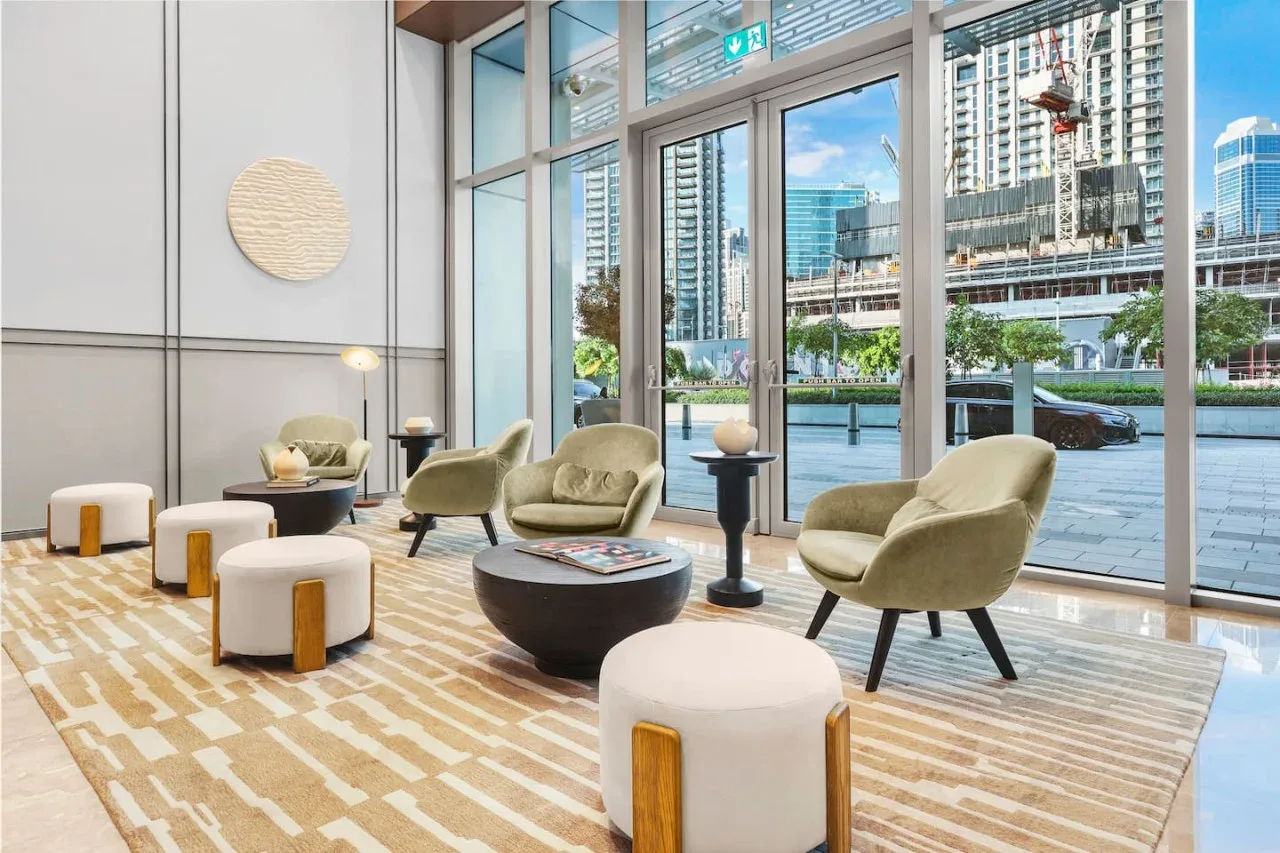 Una sala luminosa con asientos curvos y grandes ventanales con vistas a la ciudad.