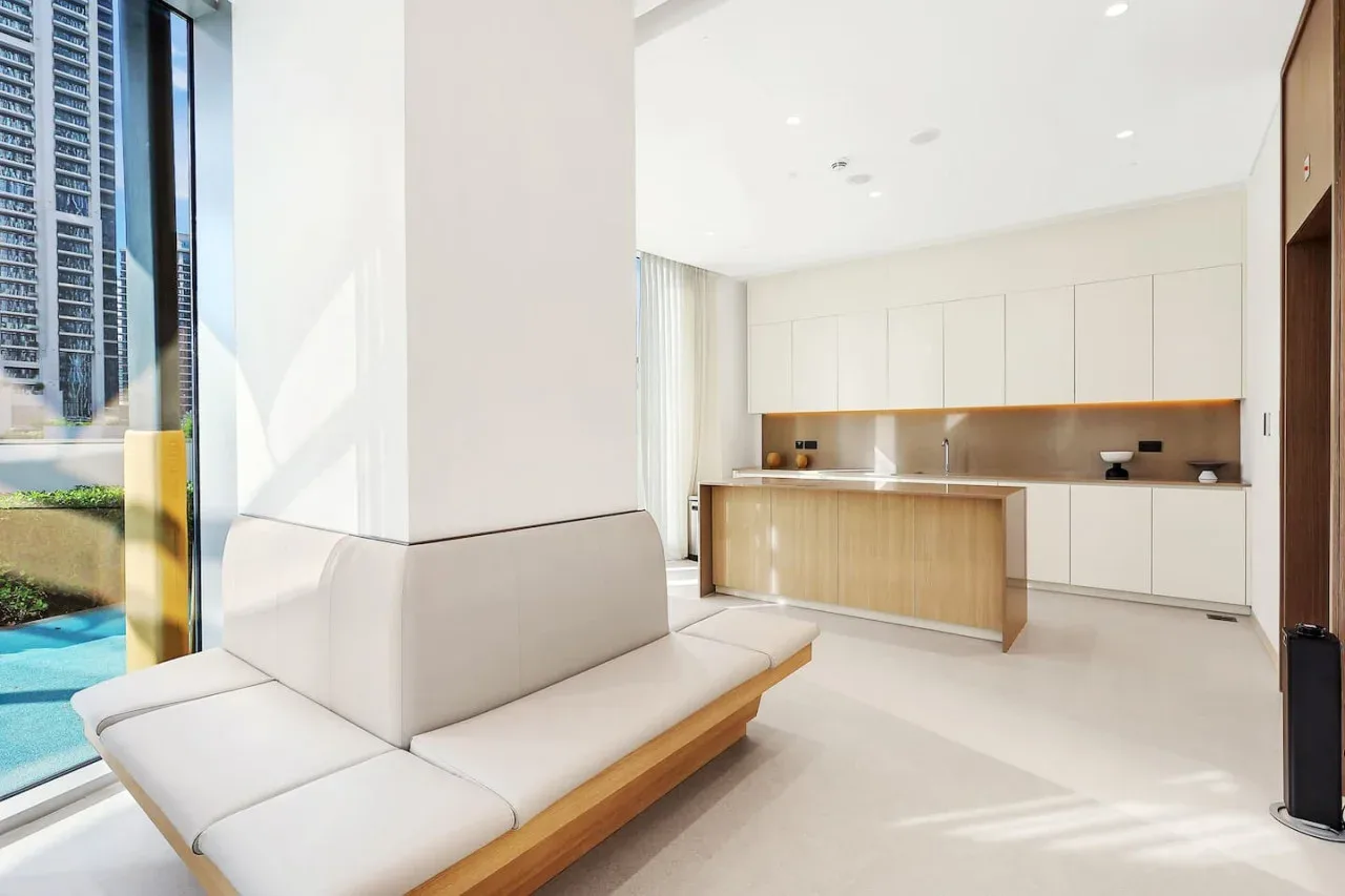 Una luminosa sala de estar abierta a la cocina, con una zona de asientos clara.