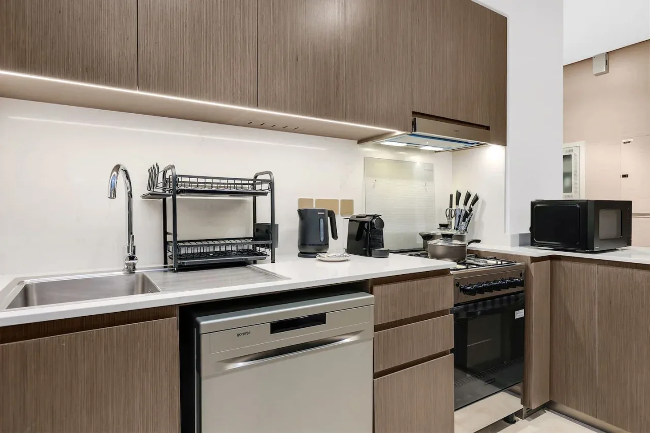 Una cocina moderna con gabinetes de madera, fregadero y electrodomésticos.