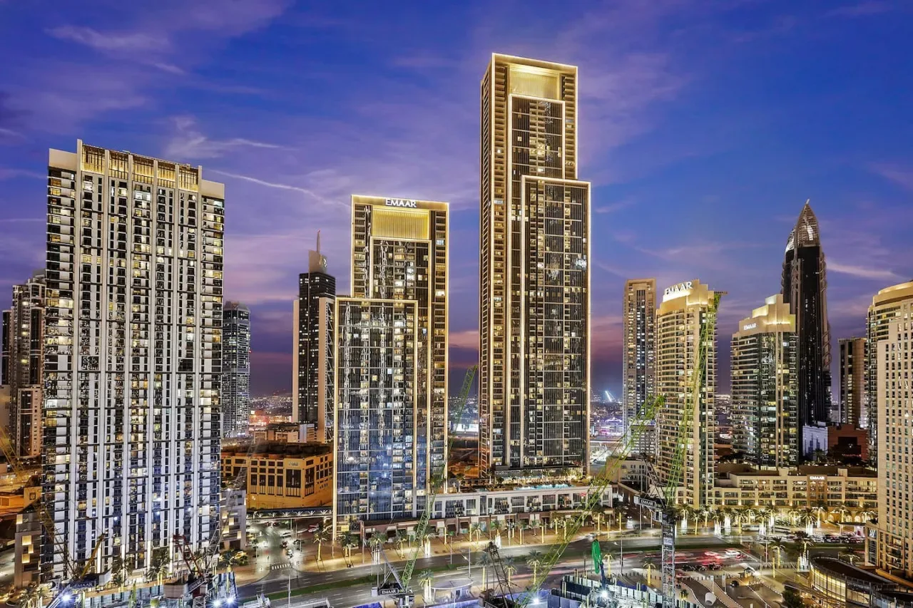 El horizonte nocturno de la ciudad muestra edificios altos iluminados y vías concurridas.