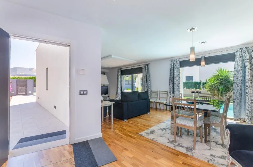 An open-plan living and dining area with seating beside large windows.