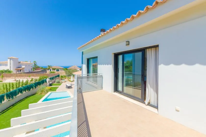 A sunny terrace overlooks a small pool and landscaped outdoor area.