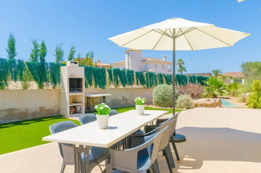 An outdoor dining area with a table beneath a large umbrella.