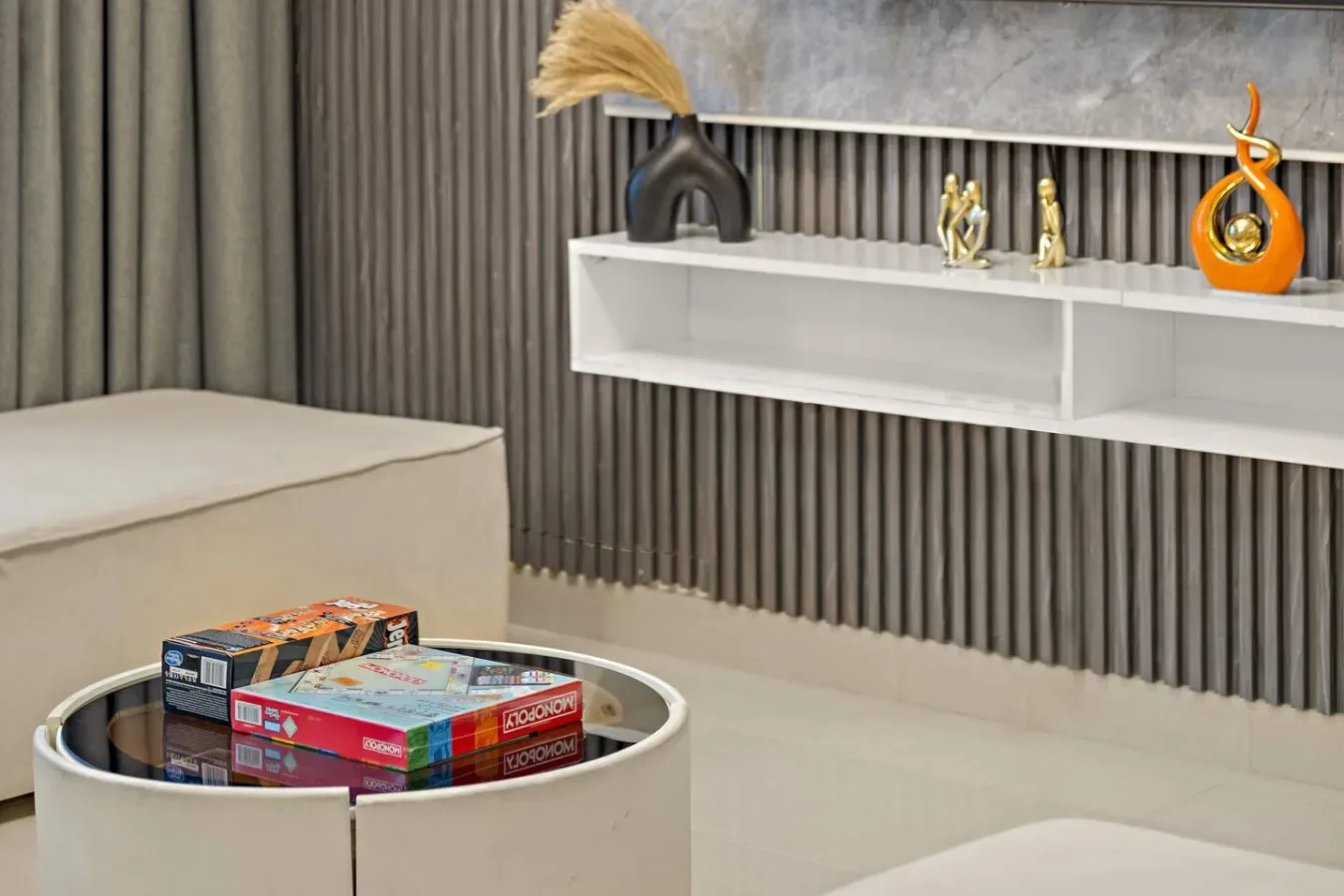 Una sala moderna con una mesa de centro redonda y un estante de pared.
