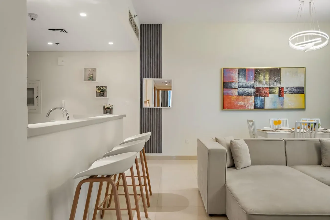 Una sala-comedor moderna de planta abierta con una barra de cocina y asientos.