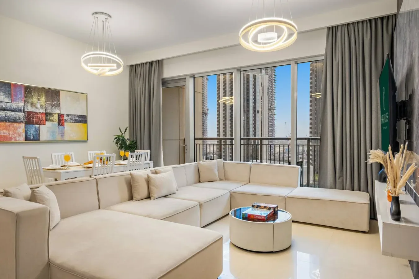A bright living room with sectional seating and large windows overlooking the city.