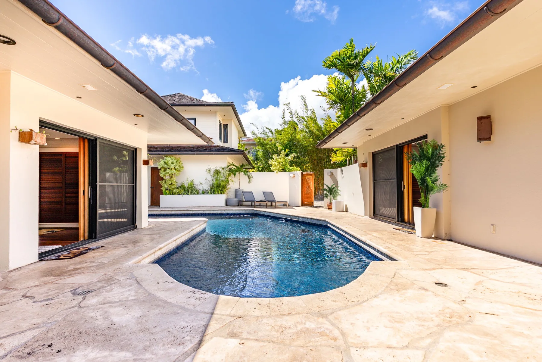 An outdoor swimming pool sits between two modern buildings.