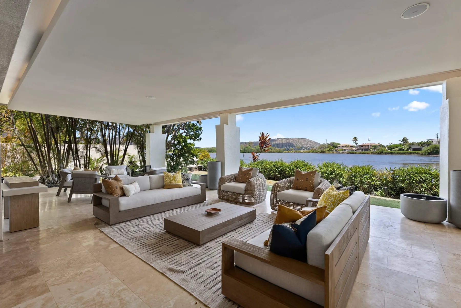 A covered outdoor lounge with seating and a view of the water.