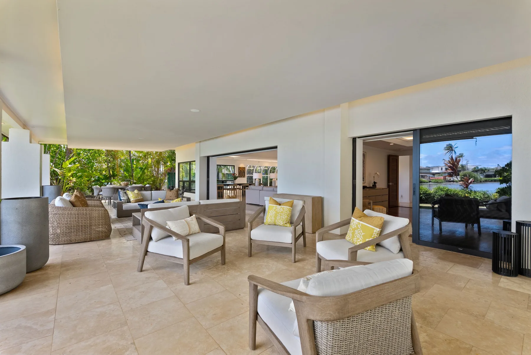 A covered lounge area has cushioned seating and sliding glass doors.