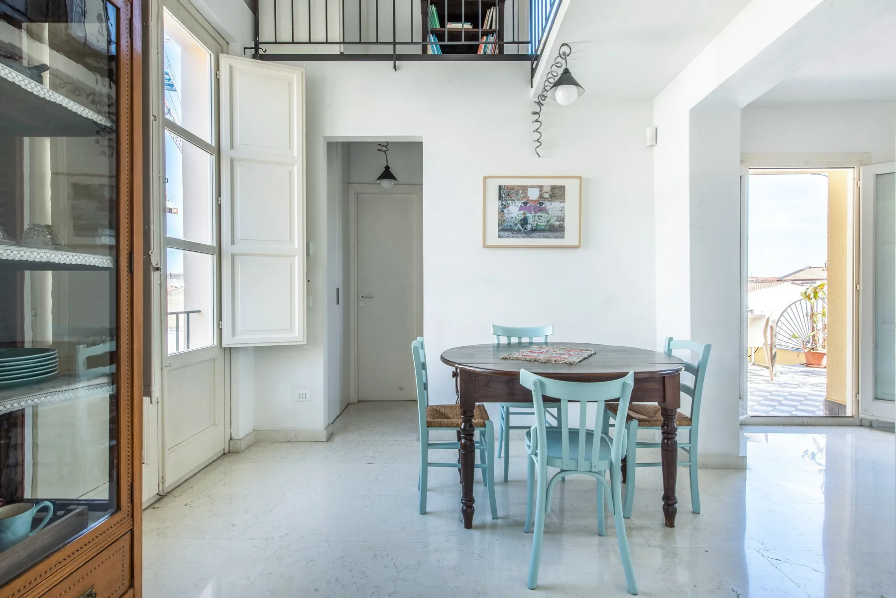 A bright dining area with a wooden table and pale blue seating.