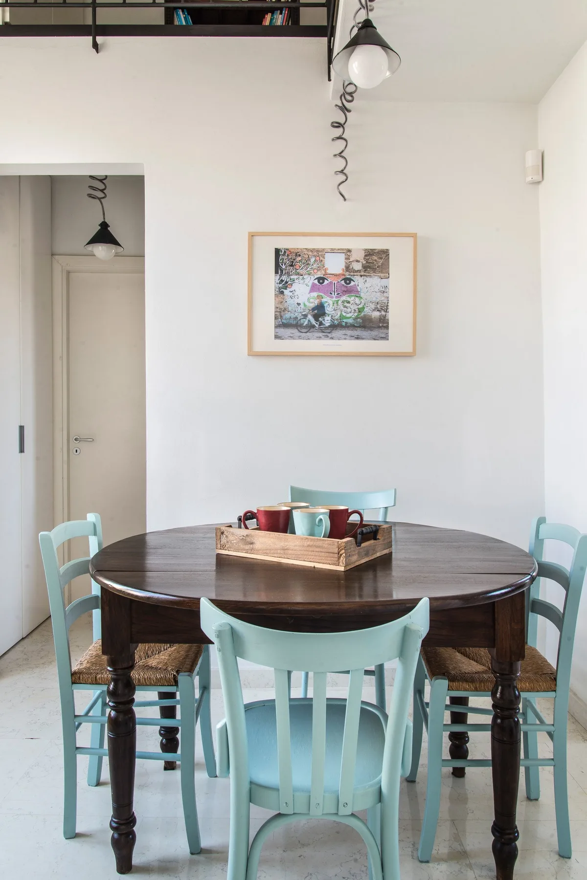 A dining area with a dark round table and turquoise seating.