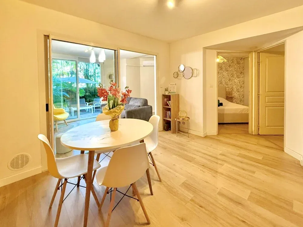 A bright dining area with a round table and an open doorway to a bedroom.