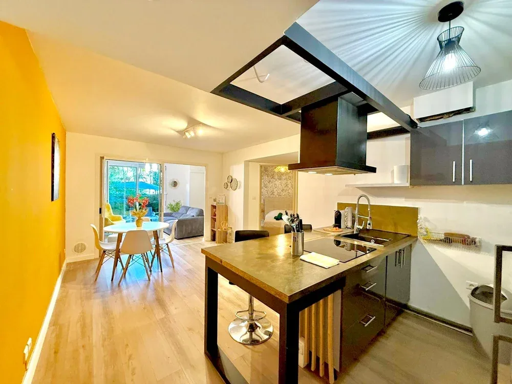 An open-plan kitchen with a central island and a dining area by the window.