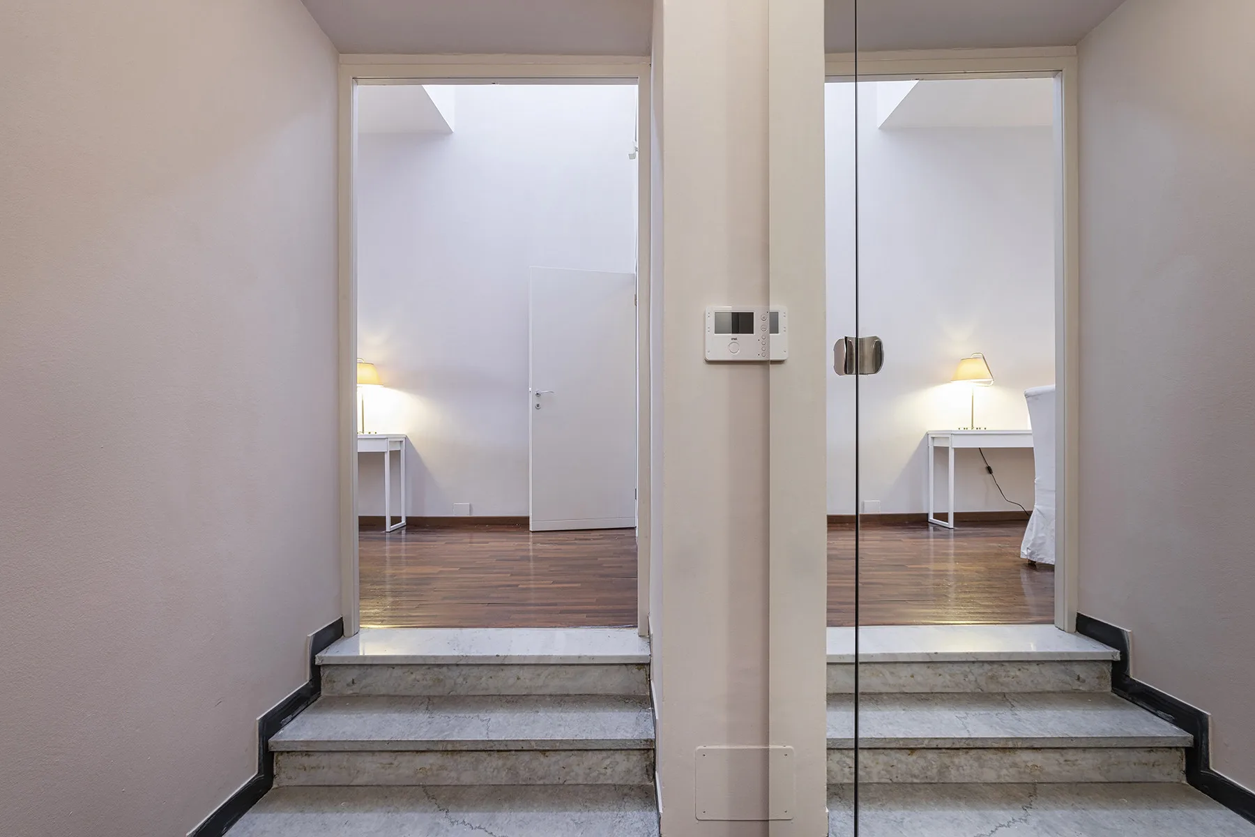 Dos escaleras conducen a habitaciones luminosas con escritorios y lámparas.
