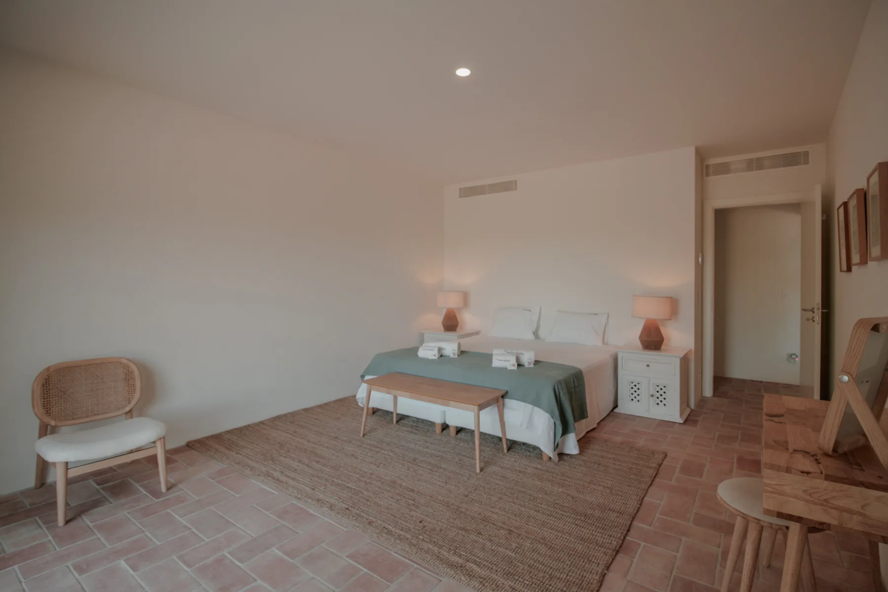 Un dormitorio con una cama, mesitas de noche y una alfombra grande.