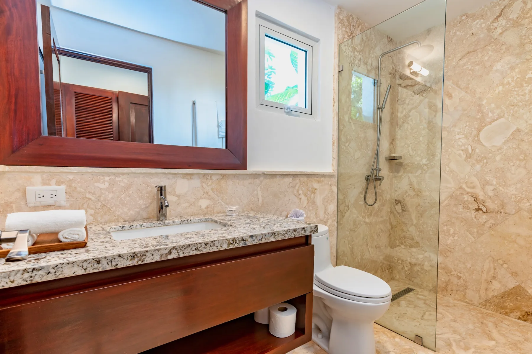 A bathroom with a wide vanity and a glass-enclosed shower.