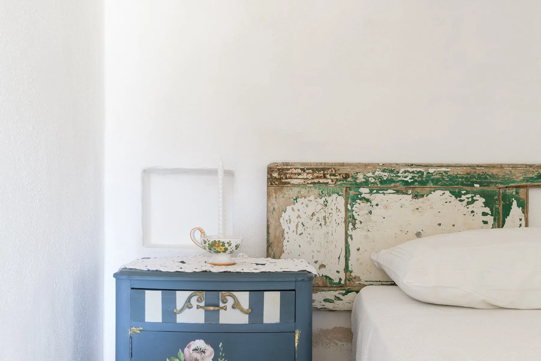 A bedroom with a blue bedside table beside a bed.