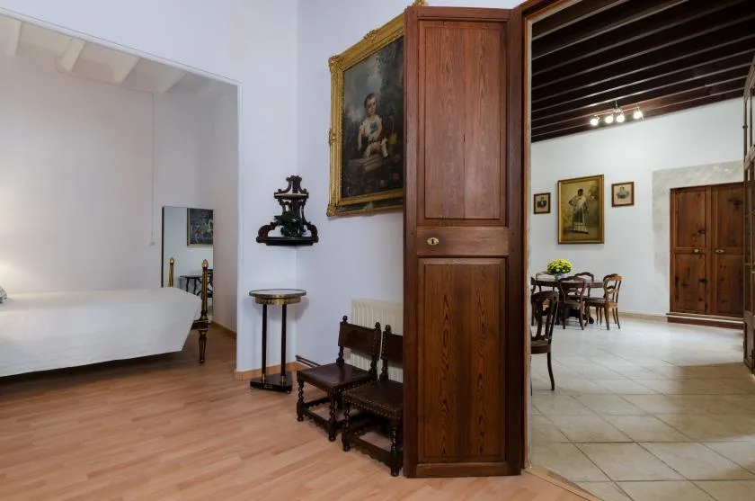 A bedroom opens onto a dining area through a wooden doorway.
