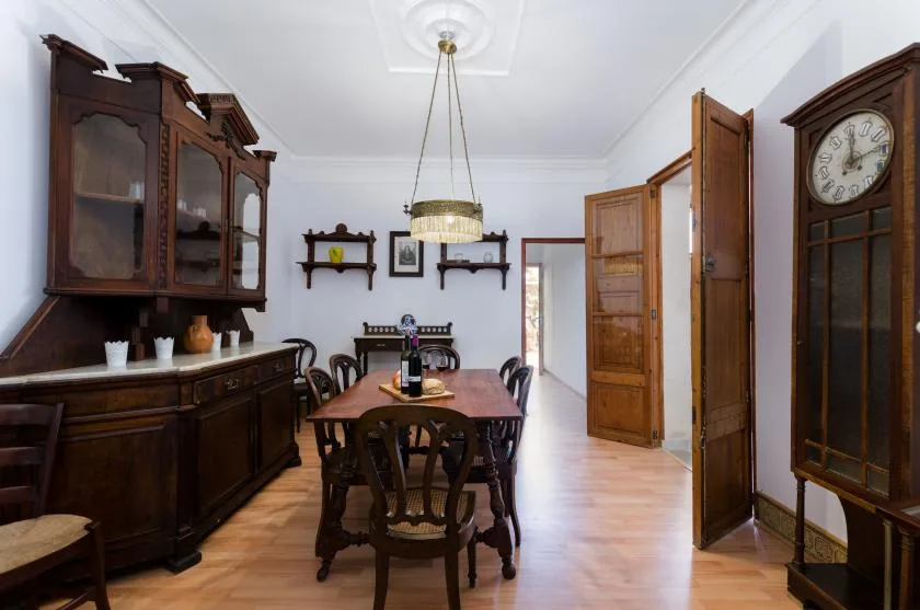 A dining room with a wooden table and dark wood cabinets.