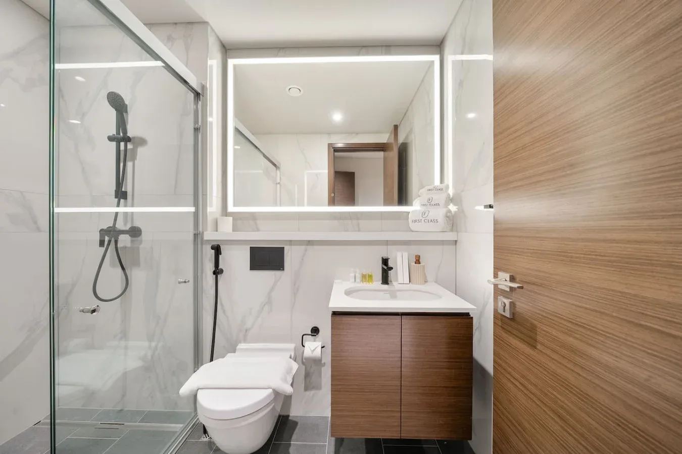 Un baño moderno con ducha de vidrio, inodoro y lavabo.