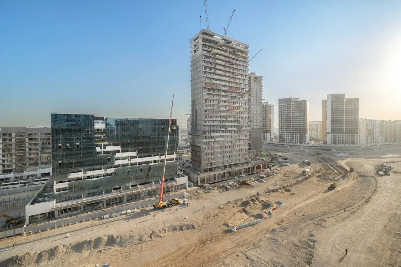 Una obra en construcción con varios edificios altos y grúas.