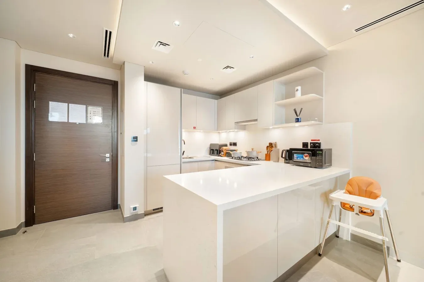 Una cocina moderna y luminosa con una isla blanca y armarios integrados.