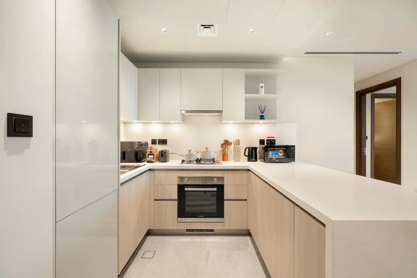 Una cocina moderna con gabinetes claros, un horno empotrado y una amplia encimera.