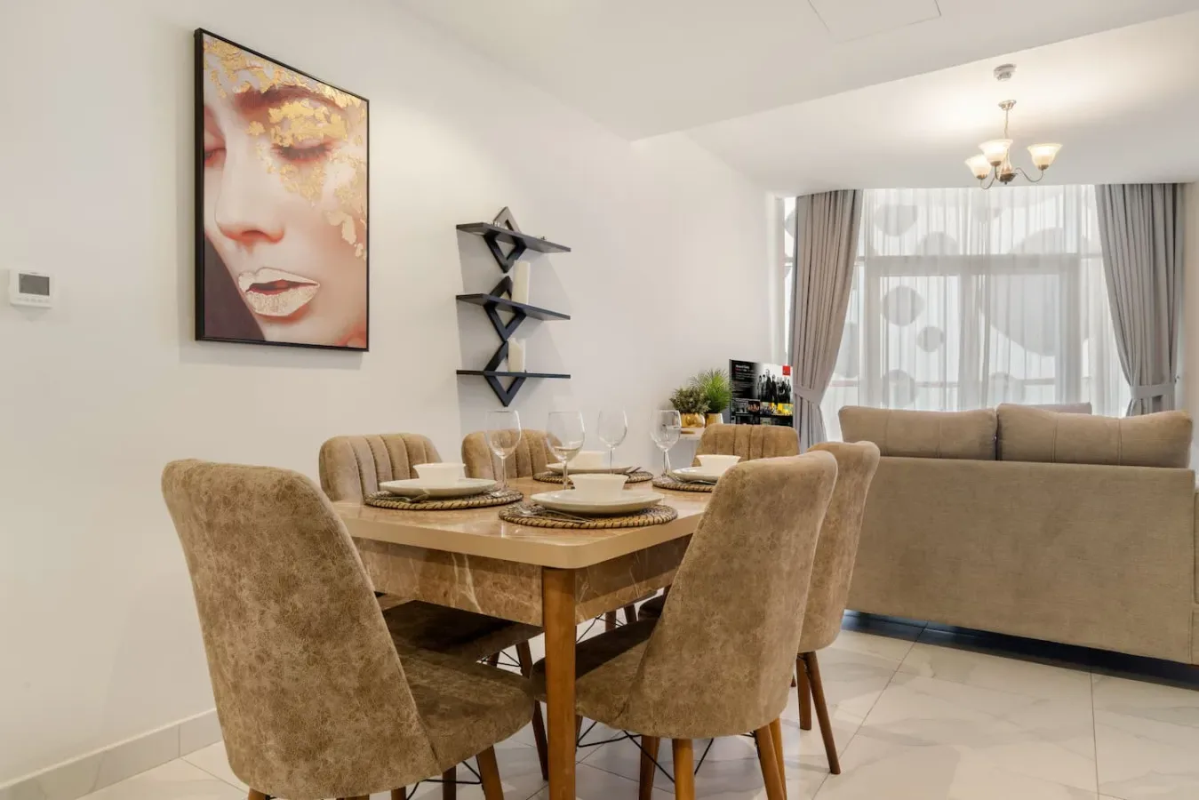 A dining area with upholstered seating, a wooden table, and framed wall art.