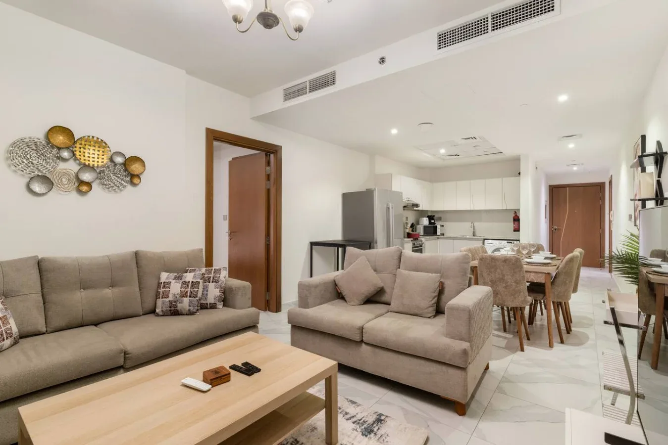 A living room with seating and a dining area in the background.