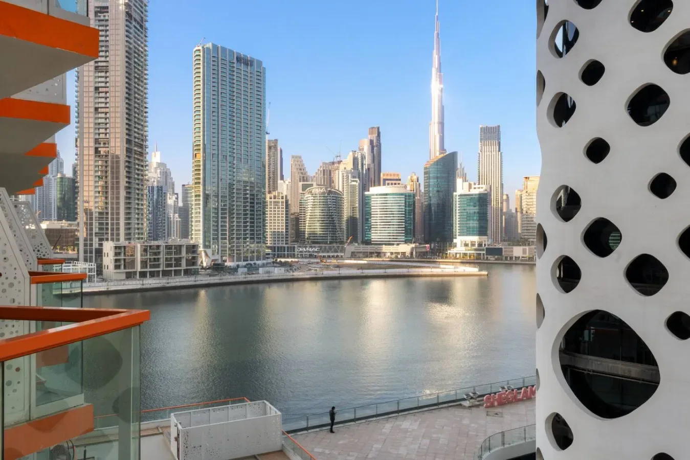 A waterfront city skyline rises across the water, with a distinctive tall tower.