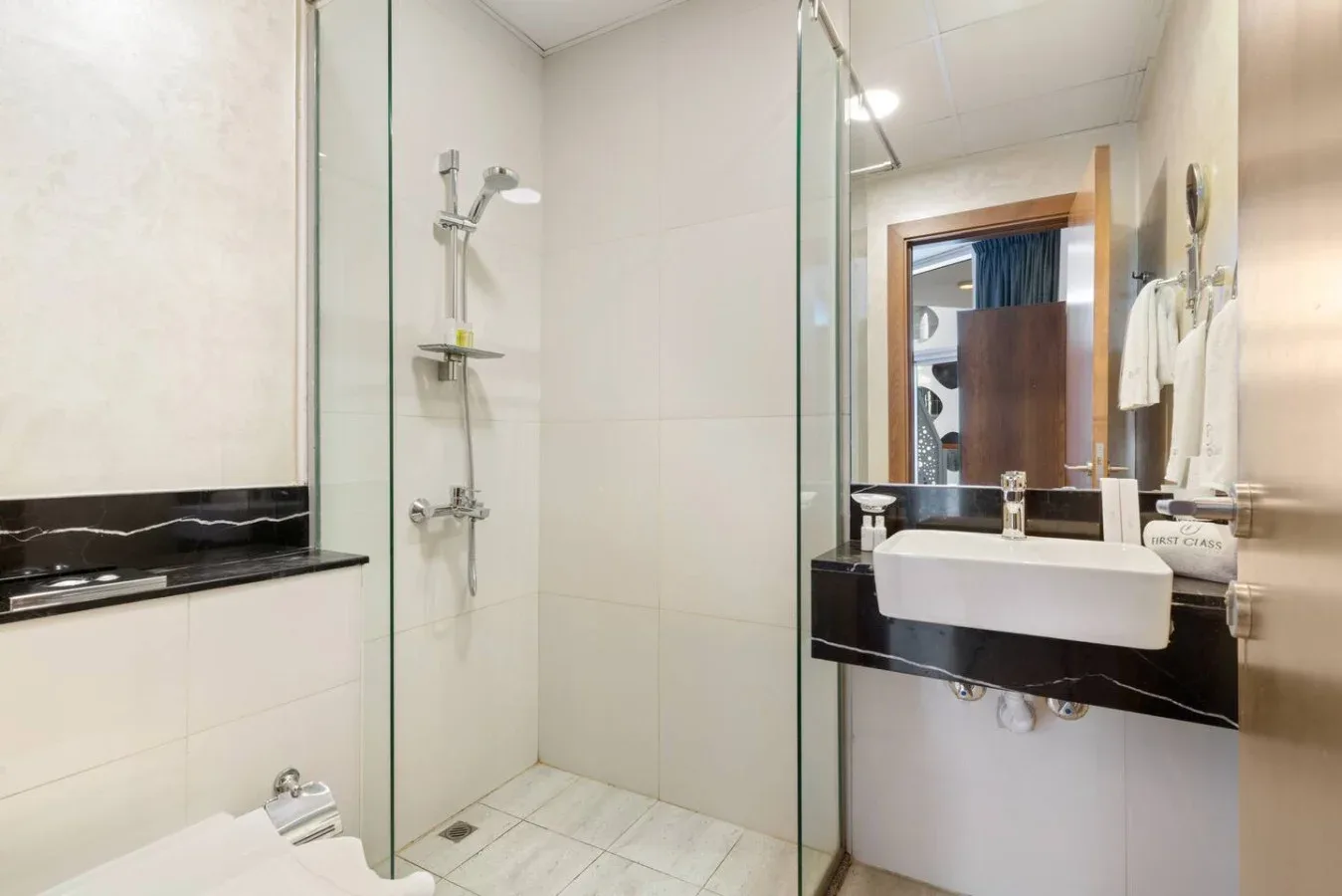 A bathroom with a glass shower and a white sink.