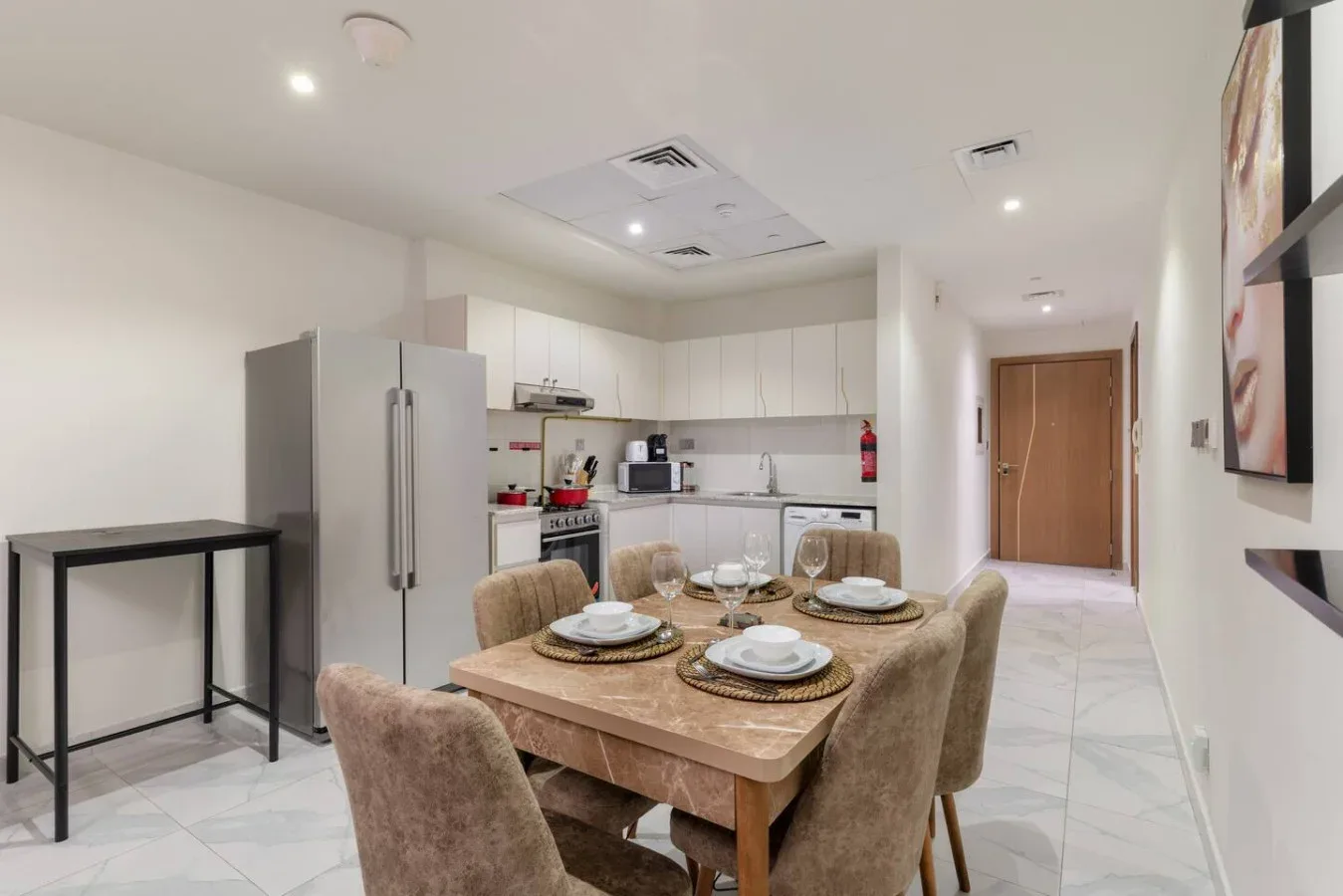 A dining area with a set table beside a kitchen.