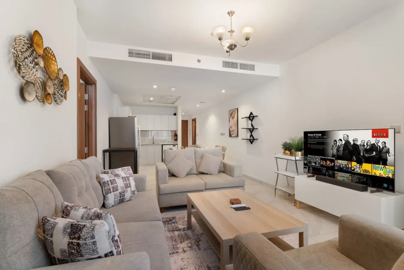 A bright living room with seating arranged around a wooden coffee table and television.