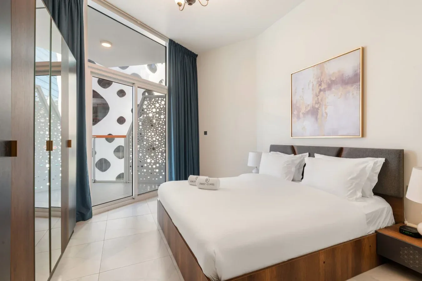 A bright bedroom with a neatly made bed and sliding glass doors.