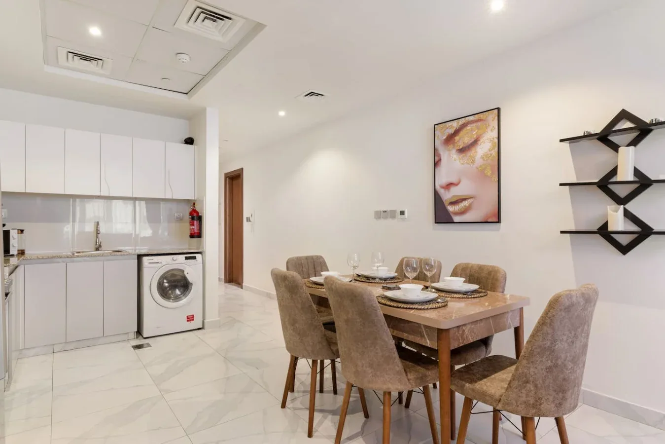 A dining area with a wooden table, upholstered seating, and white kitchen cabinets.