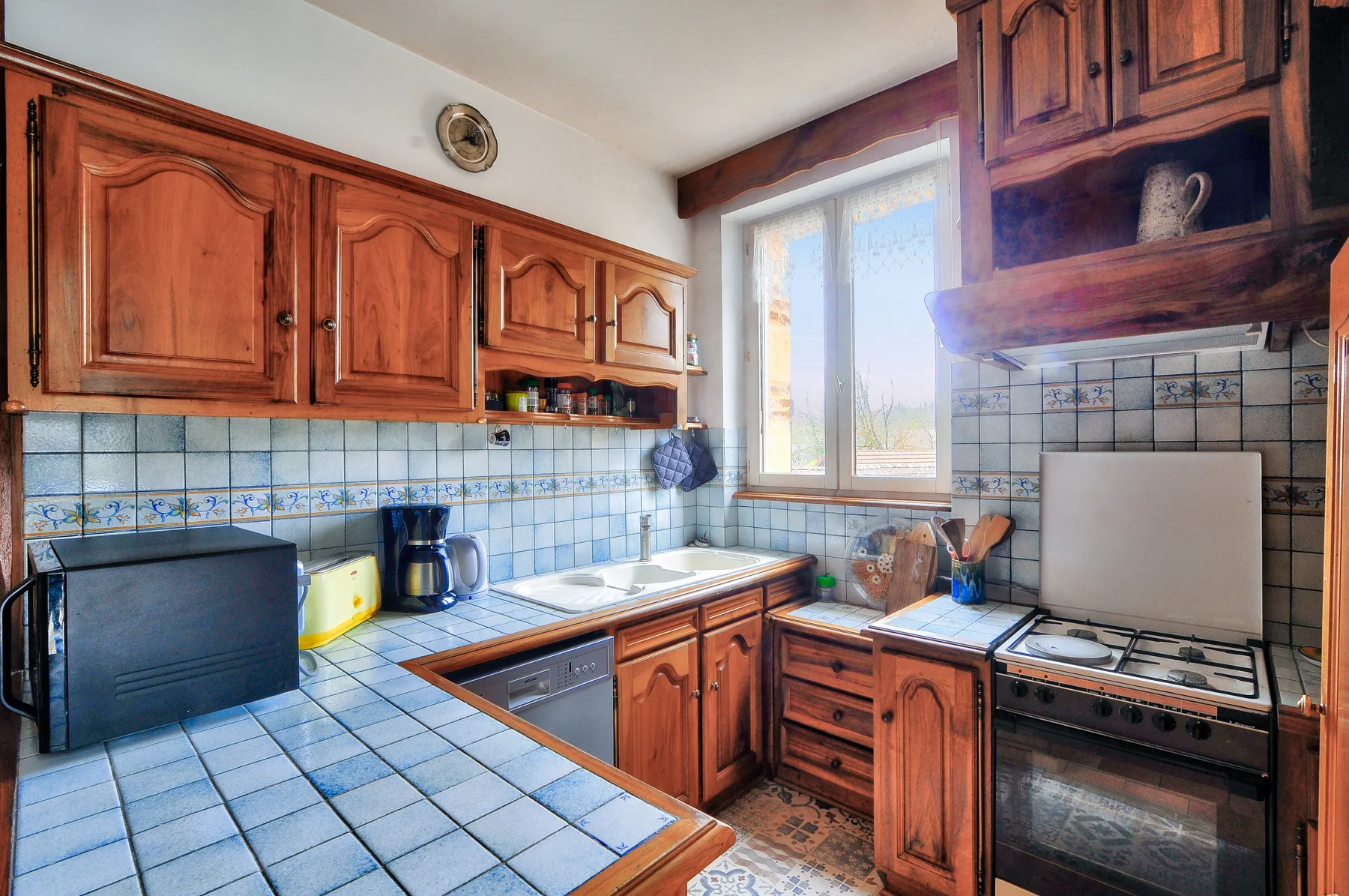 Una cocina con azulejos, armarios de madera y una encimera.