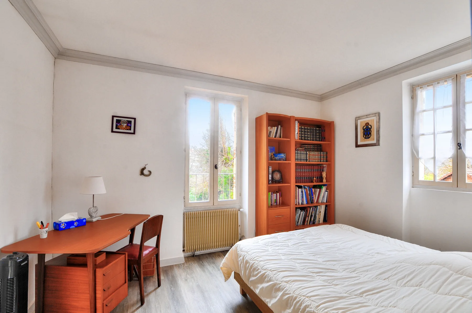 Un dormitorio con cama, escritorio y estantería.