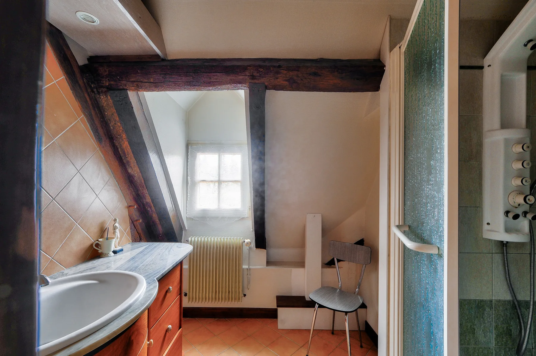 Un baño con lavabo, ducha y ventana