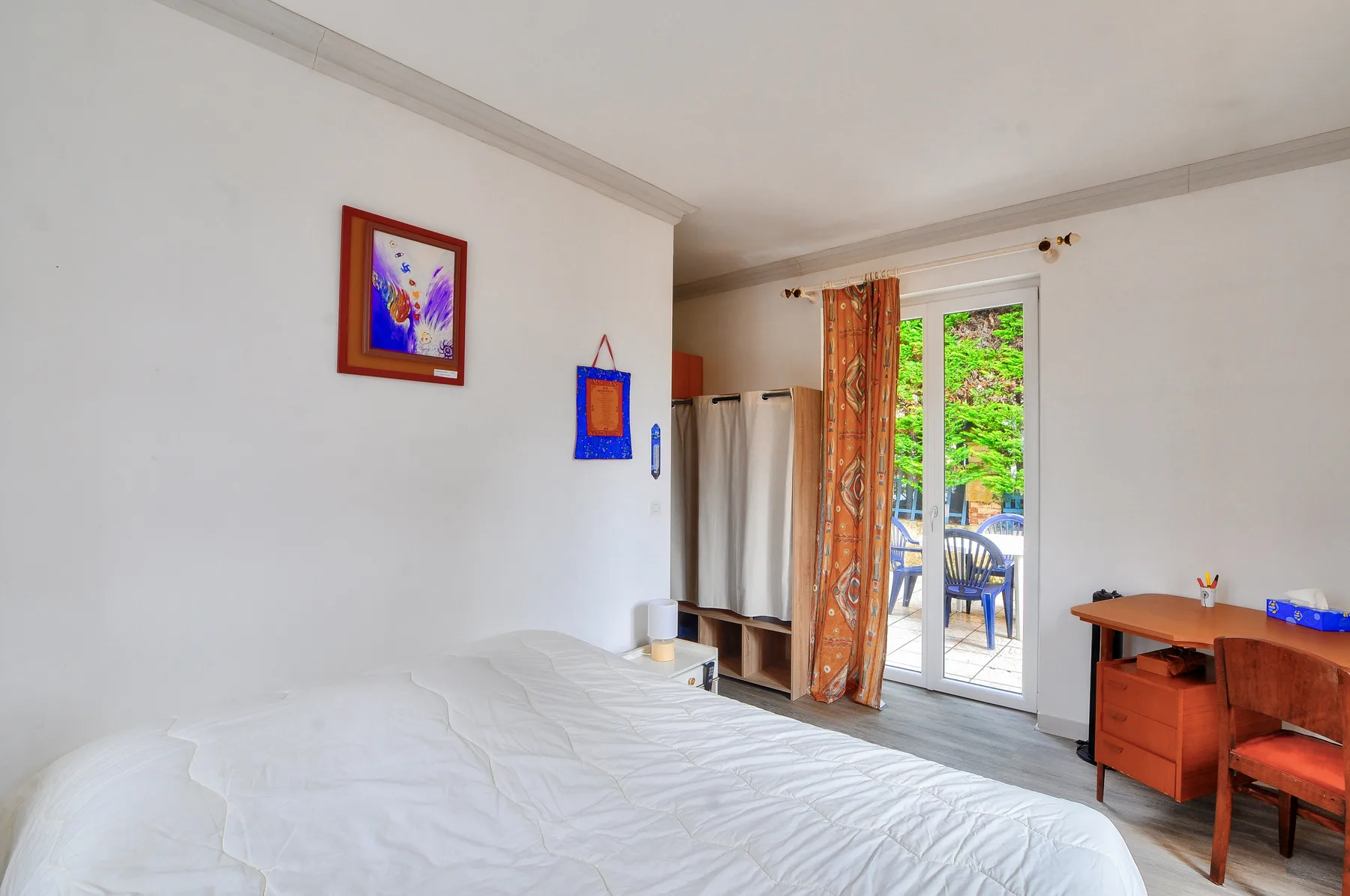 Un dormitorio con una cama junto a una puerta de cristal que da a un patio.