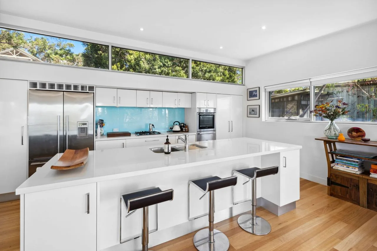 Una cocina moderna y luminosa con una isla central y asientos de barra.