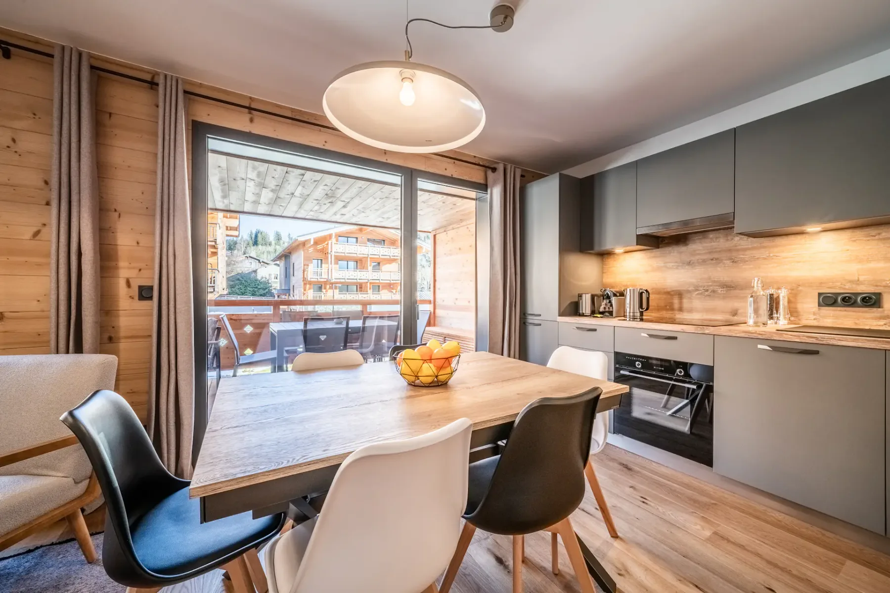 A kitchen with a table and chairs and a balcony.