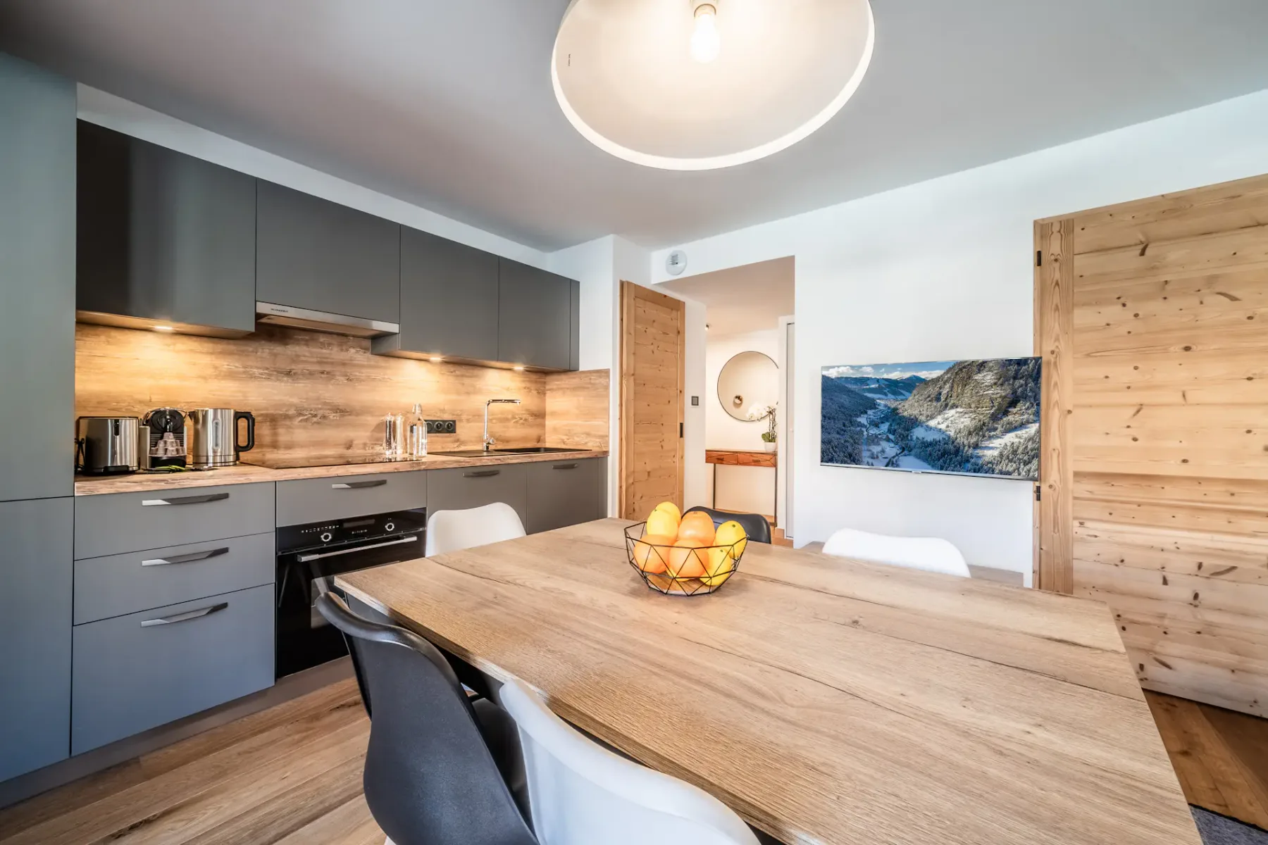A kitchen with a table and chairs and a balcony.