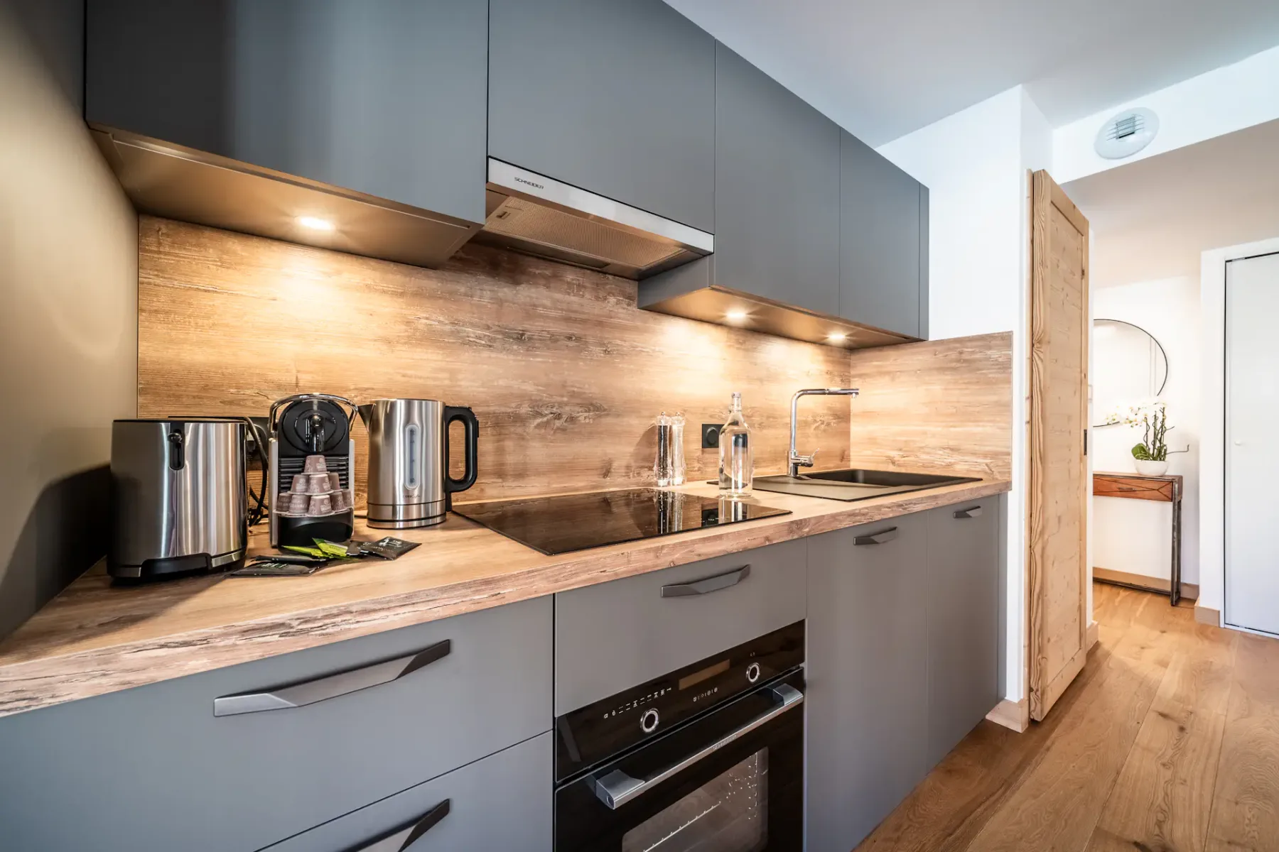 A modern kitchen with a countertop, sink, and built-in oven.