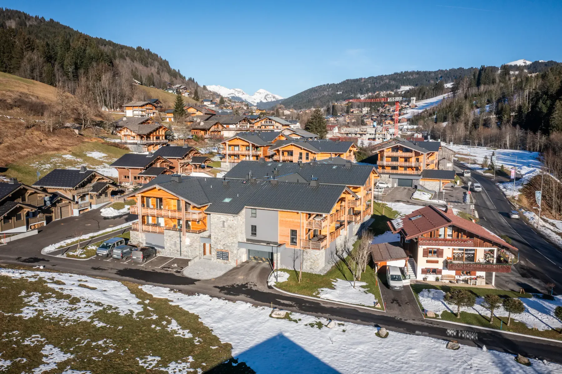 A mountain village with clustered buildings and patches of snow.