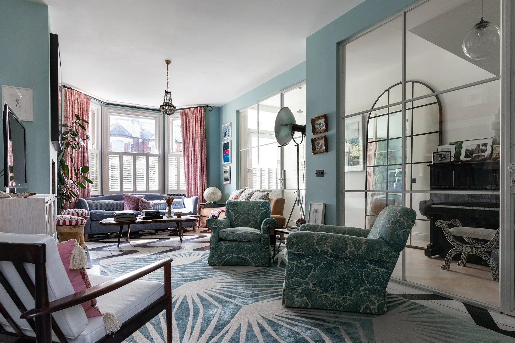 Una sala luminosa con asientos alrededor de una mesa de centro y grandes ventanas.