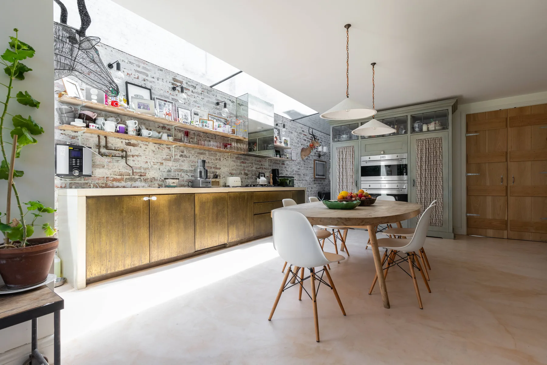 Una cocina luminosa con comedor, una encimera larga y una mesa de madera.