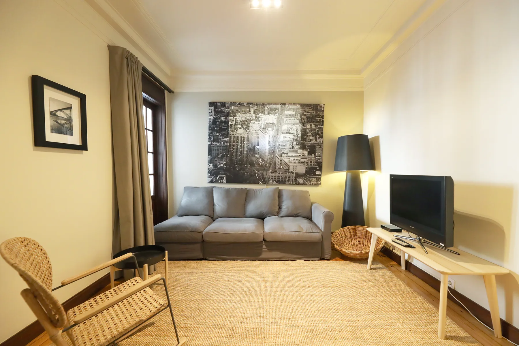 Una sala de estar con asientos, un televisor y una alfombra grande.