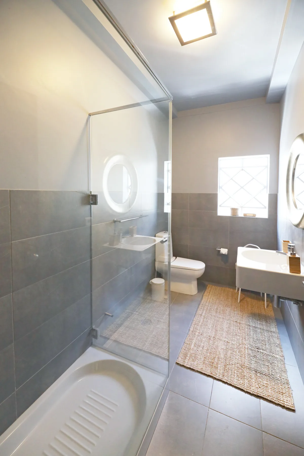 Un baño con ducha de vidrio, inodoro y lavabo.