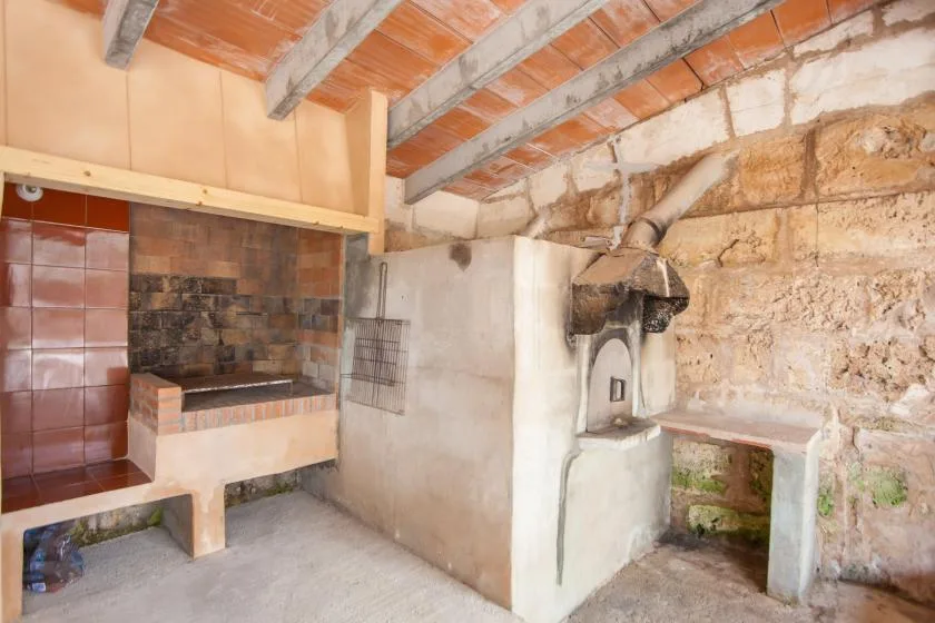 Una zona de cocina rústica con un hogar de azulejos y un horno empotrado.