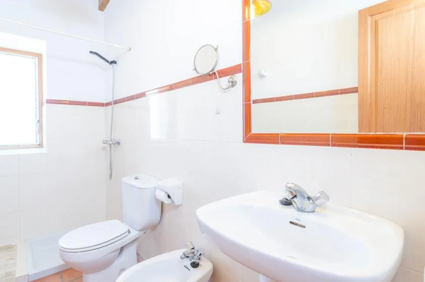 Un baño alicatado con lavabo, inodoro y ducha.